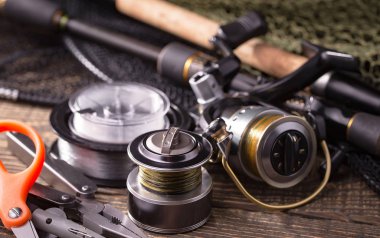 Balıkçılık çubuklar ve spinnings tablosundaki eski arka plan üzerinde balıkçılık için aksesuarlar ile kompozisyon