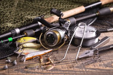 Balıkçılık çubuklar ve spinnings tablosundaki eski arka plan üzerinde balıkçılık için aksesuarlar ile kompozisyon