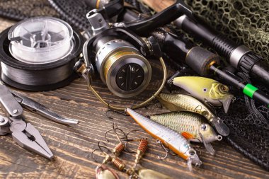 Balıkçılık çubuklar ve spinnings tablosundaki eski arka plan üzerinde balıkçılık için aksesuarlar ile kompozisyon