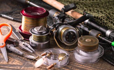 Balıkçılık çubuklar ve spinnings tablosundaki eski arka plan üzerinde balıkçılık için aksesuarlar ile kompozisyon