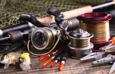 Balıkçılık çubuklar ve spinnings tablosundaki eski arka plan üzerinde balıkçılık için aksesuarlar ile kompozisyon