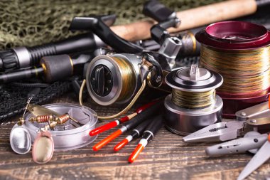 Balıkçılık çubuklar ve spinnings tablosundaki eski arka plan üzerinde balıkçılık için aksesuarlar ile kompozisyon