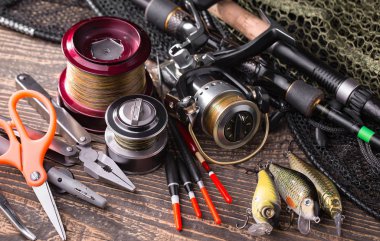 Balıkçılık çubuklar ve spinnings tablosundaki eski arka plan üzerinde balıkçılık için aksesuarlar ile kompozisyon