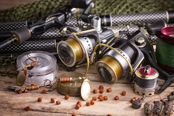 Balıkçılık çubuklar ve spinnings tablosundaki eski arka plan üzerinde balıkçılık için aksesuarlar ile kompozisyon
