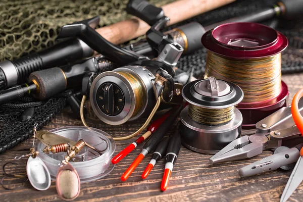 Balıkçılık çubuklar ve spinnings tablosundaki eski arka plan üzerinde balıkçılık için aksesuarlar ile kompozisyon