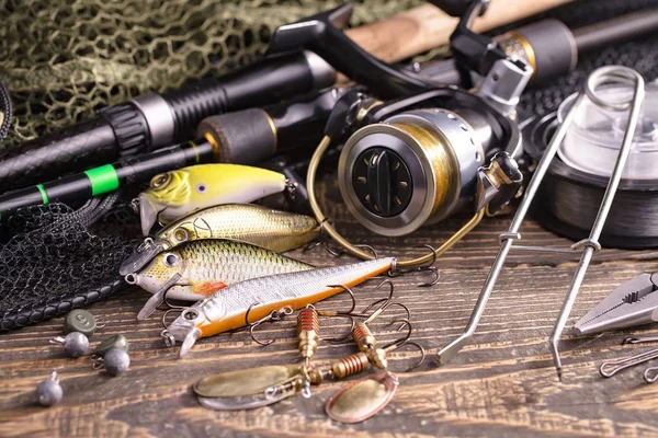 Balıkçılık çubuklar ve spinnings tablosundaki eski arka plan üzerinde balıkçılık için aksesuarlar ile kompozisyon