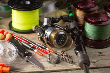 Balıkçılık çubuklar ve spinnings tablosundaki eski arka plan üzerinde balıkçılık için aksesuarlar ile kompozisyon