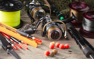 Balıkçılık çubuklar ve spinnings tablosundaki eski arka plan üzerinde balıkçılık için aksesuarlar ile kompozisyon