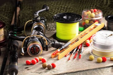 Balıkçılık çubuklar ve spinnings tablosundaki eski arka plan üzerinde balıkçılık için aksesuarlar ile kompozisyon