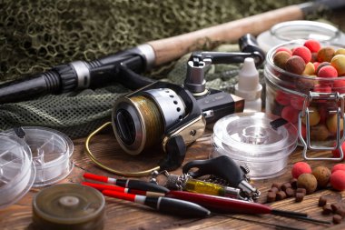 Balıkçılık çubuklar ve spinnings tablosundaki eski arka plan üzerinde balıkçılık için aksesuarlar ile kompozisyon