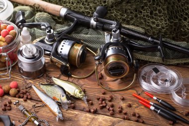 Balıkçılık çubuklar ve spinnings tablosundaki eski arka plan üzerinde balıkçılık için aksesuarlar ile kompozisyon
