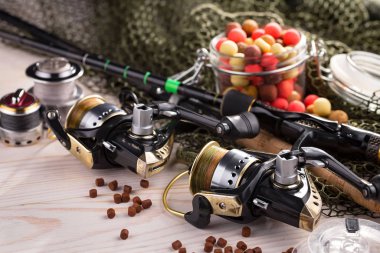 Balıkçılık çubuklar ve spinnings tablosundaki eski arka plan üzerinde balıkçılık için aksesuarlar ile kompozisyon