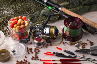 Balıkçılık çubuklar ve spinnings tablosundaki eski arka plan üzerinde balıkçılık için aksesuarlar ile kompozisyon