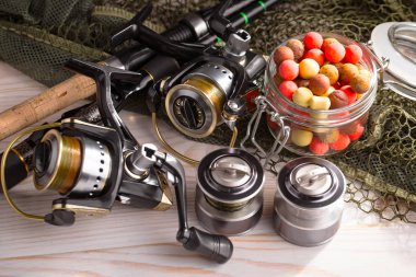 Balıkçılık çubuklar ve spinnings tablosundaki eski arka plan üzerinde balıkçılık için aksesuarlar ile kompozisyon