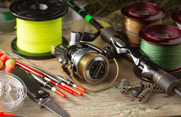 Balıkçılık çubuklar ve spinnings tablosundaki eski arka plan üzerinde balıkçılık için aksesuarlar ile kompozisyon