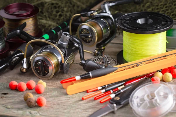 Balıkçılık çubuklar ve spinnings tablosundaki eski arka plan üzerinde balıkçılık için aksesuarlar ile kompozisyon