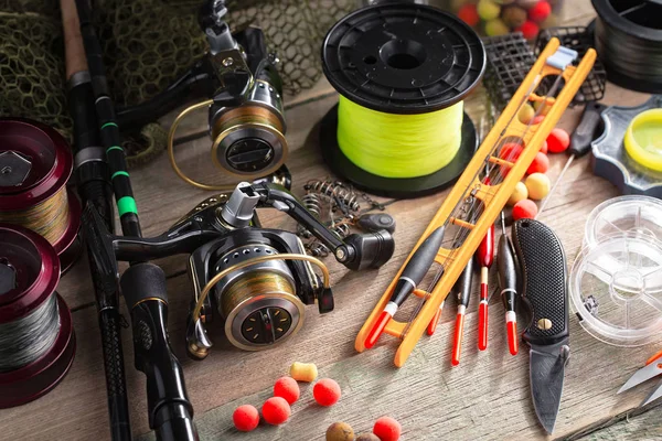 Balıkçılık çubuklar ve spinnings tablosundaki eski arka plan üzerinde balıkçılık için aksesuarlar ile kompozisyon