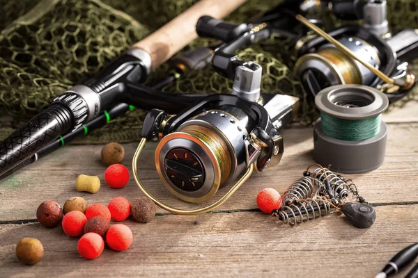 Balıkçılık çubuklar ve spinnings tablosundaki eski arka plan üzerinde balıkçılık için aksesuarlar ile kompozisyon