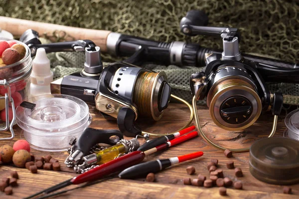 Balıkçılık çubuklar ve spinnings tablosundaki eski arka plan üzerinde balıkçılık için aksesuarlar ile kompozisyon