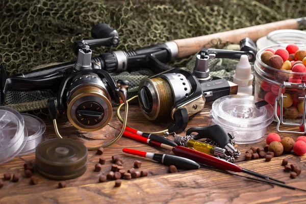 Balıkçılık çubuklar ve spinnings tablosundaki eski arka plan üzerinde balıkçılık için aksesuarlar ile kompozisyon