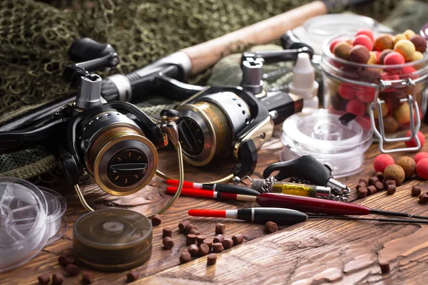 Balıkçılık çubuklar ve spinnings tablosundaki eski arka plan üzerinde balıkçılık için aksesuarlar ile kompozisyon