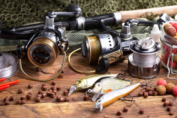 Balıkçılık çubuklar ve spinnings tablosundaki eski arka plan üzerinde balıkçılık için aksesuarlar ile kompozisyon