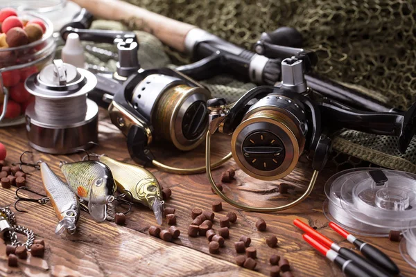 Balıkçılık çubuklar ve spinnings tablosundaki eski arka plan üzerinde balıkçılık için aksesuarlar ile kompozisyon