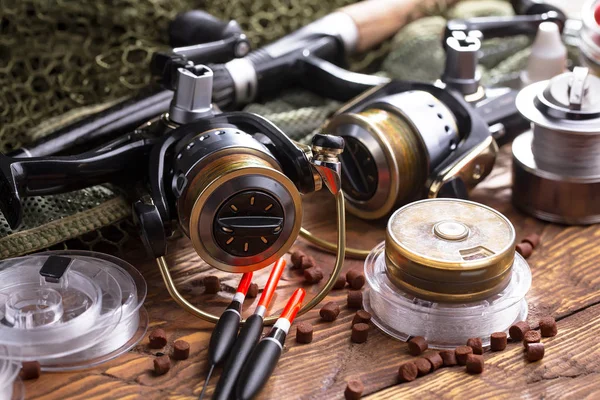 Balıkçılık çubuklar ve spinnings tablosundaki eski arka plan üzerinde balıkçılık için aksesuarlar ile kompozisyon