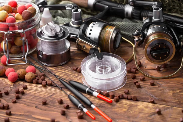 Balıkçılık çubuklar ve spinnings tablosundaki eski arka plan üzerinde balıkçılık için aksesuarlar ile kompozisyon