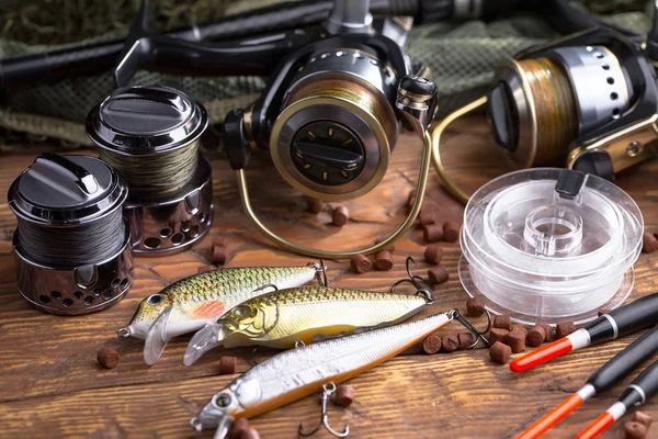 Balıkçılık çubuklar ve spinnings tablosundaki eski arka plan üzerinde balıkçılık için aksesuarlar ile kompozisyon
