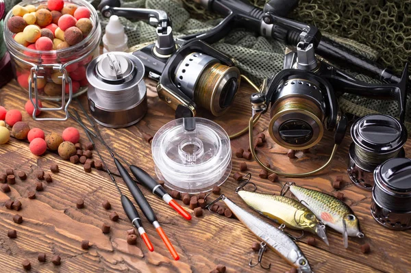 Balıkçılık çubuklar ve spinnings tablosundaki eski arka plan üzerinde balıkçılık için aksesuarlar ile kompozisyon