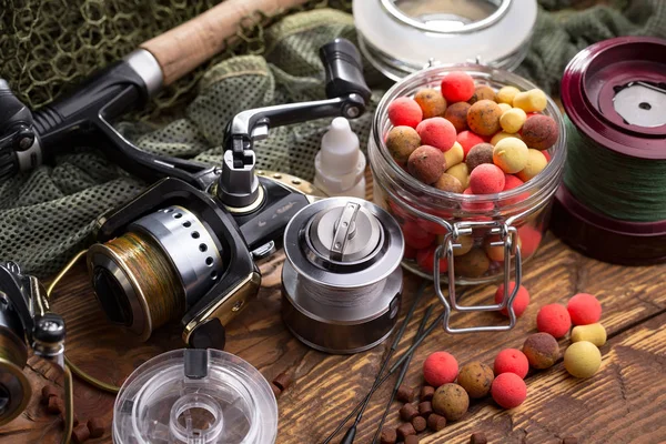 Balıkçılık çubuklar ve spinnings tablosundaki eski arka plan üzerinde balıkçılık için aksesuarlar ile kompozisyon