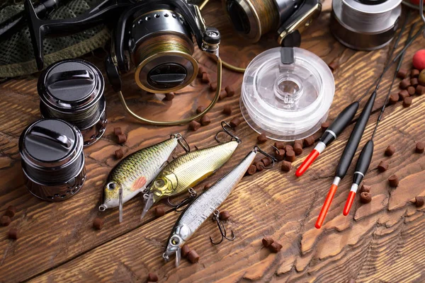 Balıkçılık çubuklar ve spinnings tablosundaki eski arka plan üzerinde balıkçılık için aksesuarlar ile kompozisyon