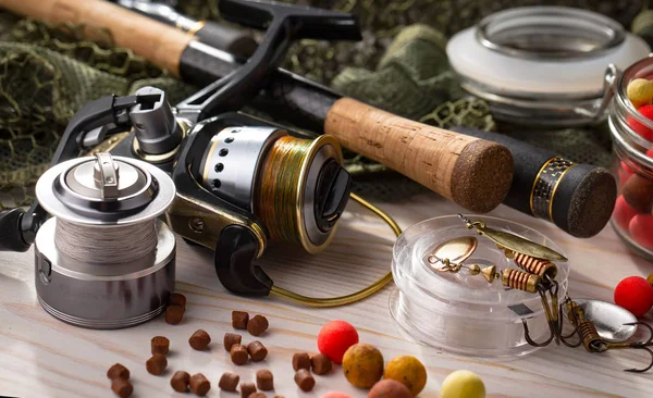 Balıkçılık çubuklar ve spinnings tablosundaki eski arka plan üzerinde balıkçılık için aksesuarlar ile kompozisyon