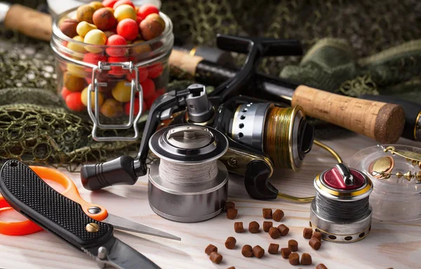 Balıkçılık çubuklar ve spinnings tablosundaki eski arka plan üzerinde balıkçılık için aksesuarlar ile kompozisyon