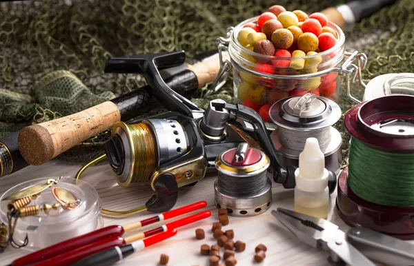 Balıkçılık çubuklar ve spinnings tablosundaki eski arka plan üzerinde balıkçılık için aksesuarlar ile kompozisyon
