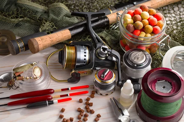 Balıkçılık çubuklar ve spinnings tablosundaki eski arka plan üzerinde balıkçılık için aksesuarlar ile kompozisyon