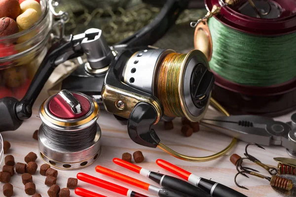 Balıkçılık çubuklar ve spinnings tablosundaki eski arka plan üzerinde balıkçılık için aksesuarlar ile kompozisyon