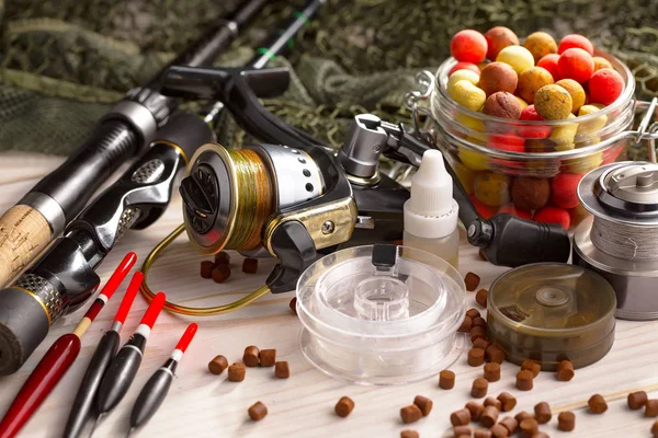 Balıkçılık çubuklar ve spinnings tablosundaki eski arka plan üzerinde balıkçılık için aksesuarlar ile kompozisyon