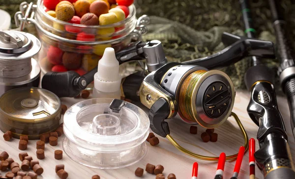 Balıkçılık çubuklar ve spinnings tablosundaki eski arka plan üzerinde balıkçılık için aksesuarlar ile kompozisyon