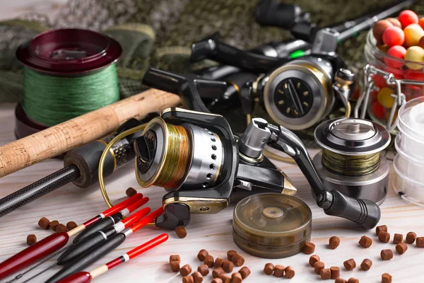 Balıkçılık çubuklar ve spinnings tablosundaki eski arka plan üzerinde balıkçılık için aksesuarlar ile kompozisyon