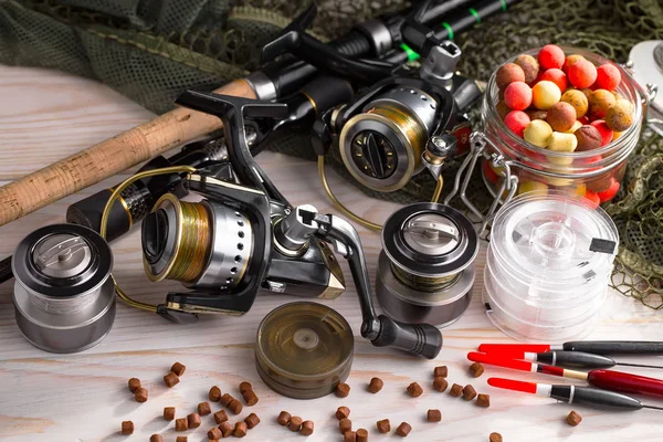 Balıkçılık çubuklar ve spinnings tablosundaki eski arka plan üzerinde balıkçılık için aksesuarlar ile kompozisyon