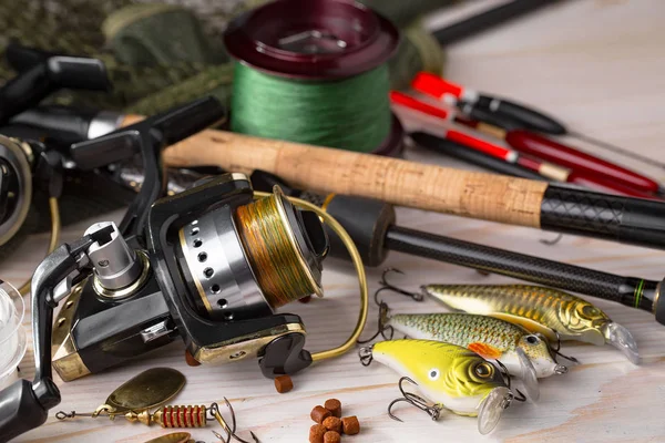 Balıkçılık çubuklar ve spinnings tablosundaki eski arka plan üzerinde balıkçılık için aksesuarlar ile kompozisyon