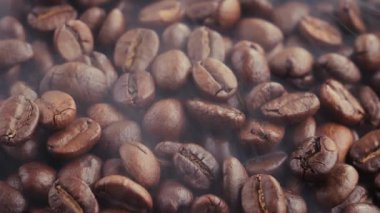 Kavrulmuş kahve çekirdekleri ve tavada duman.