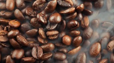 Kavrulmuş kahve çekirdekleri ve tavada duman.