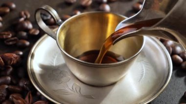 Kahve makinesinden fincana sıcak kahve dökülüyor..
