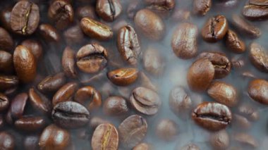 Kavrulmuş kahve çekirdekleri ve tavada duman.