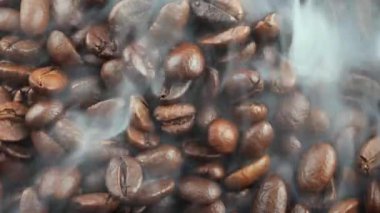 Kavrulmuş kahve çekirdekleri ve tavada duman.
