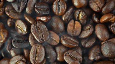 Kavrulmuş kahve çekirdekleri ve tavada duman.