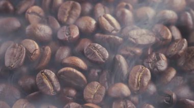 Kavrulmuş kahve çekirdekleri ve tavada duman.